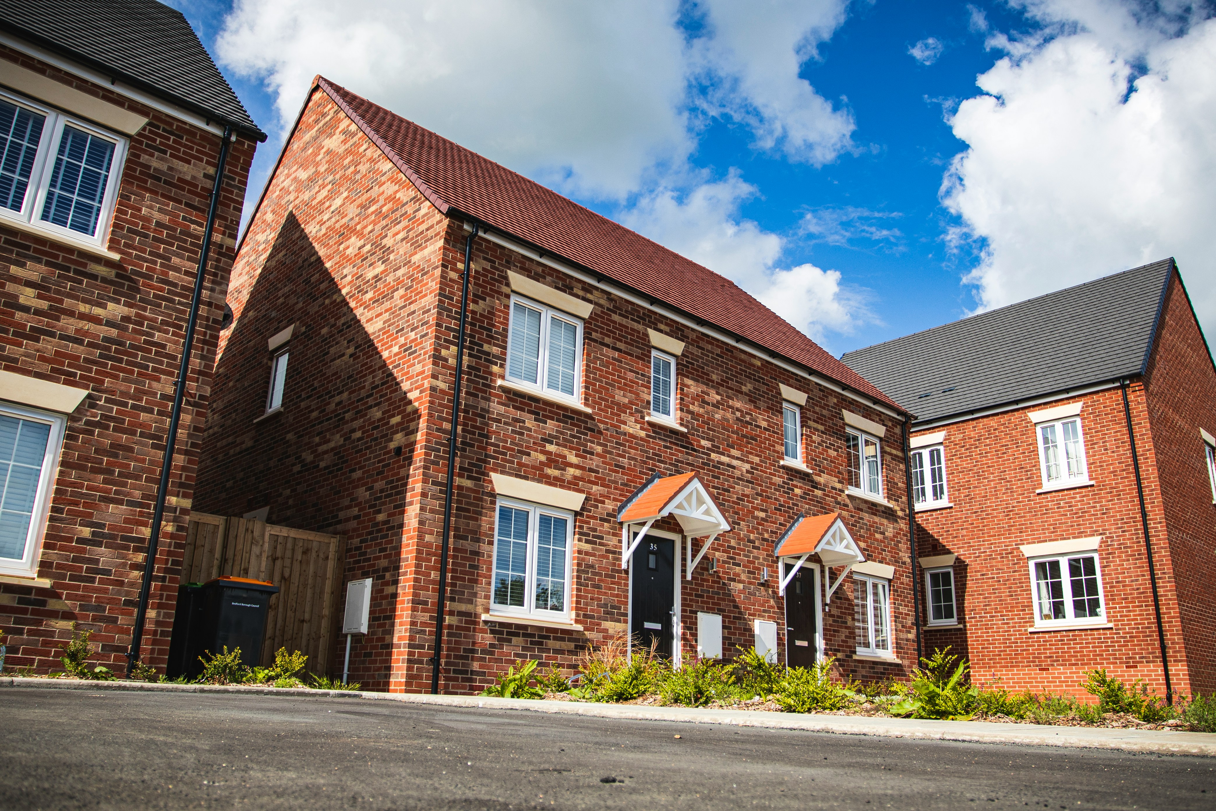 Row of modern brick homes under a blue sky